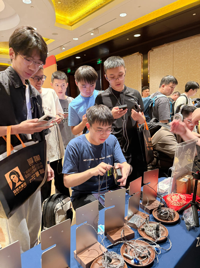 Visitors trying BQEYZ earphones at an audio exhibition, July 2025